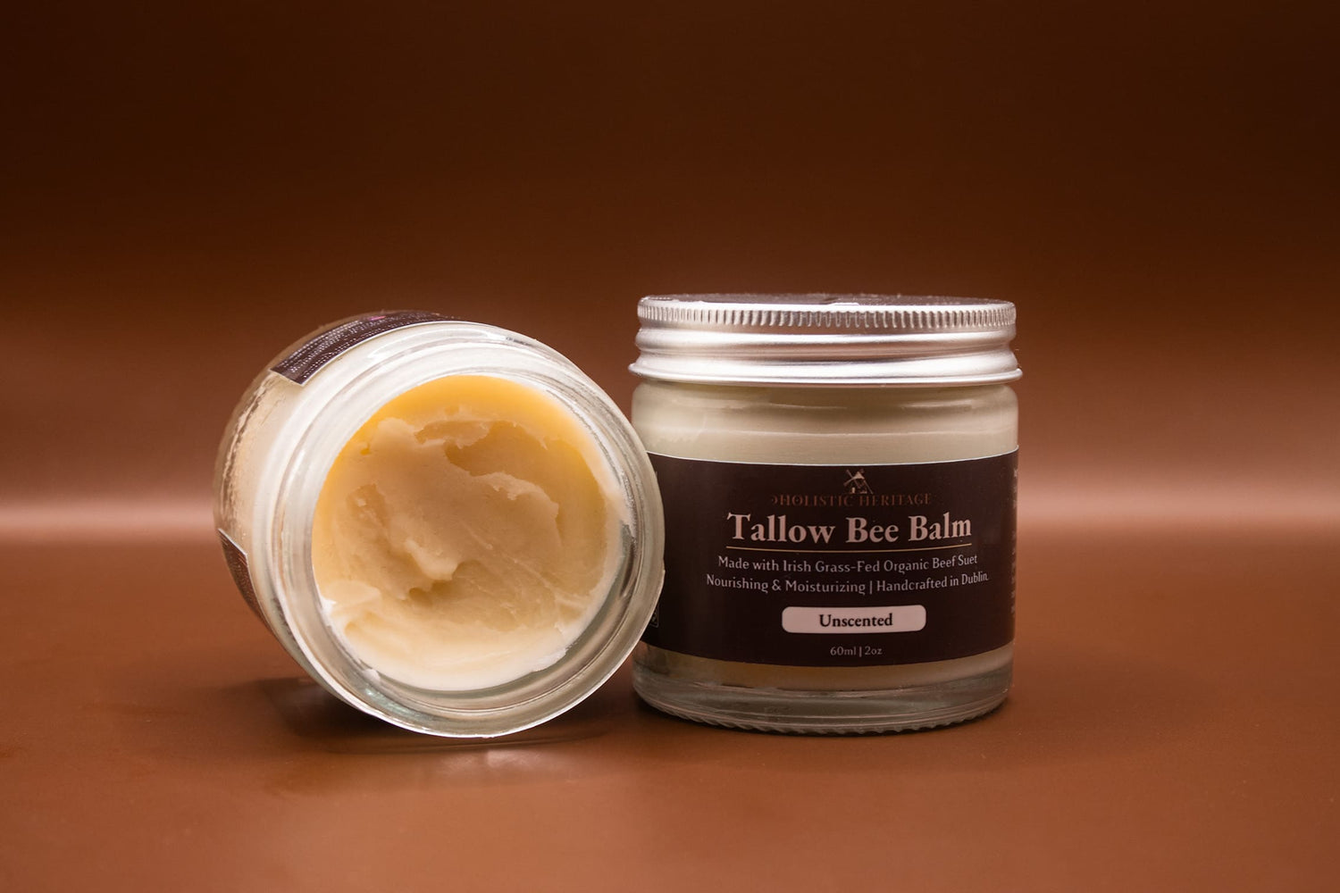 Holistic Heritage Unscented Tallow Bee Balm – open jar showing balm texture and closed labeled jar
